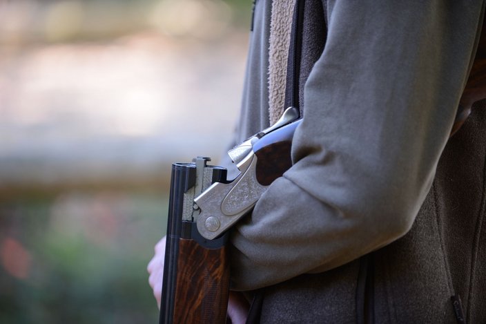Foto: Markus Ulmer Eine Flinte liegt geöffnet im Arm einer Person, die eine dunkelgrüne Jacke trägt. Die Umgebung ist verschwommen und sieht nach Natur aus.